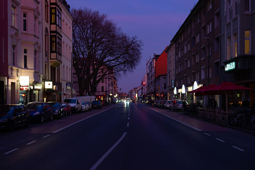 Empty Subbelrather Strasse in Cologne-Ehrenfeld at dusk lined with restaurants and bars