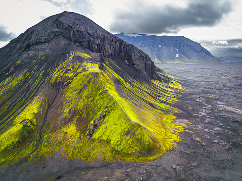 The colorful mountains of Iceland made by a volcano eruption in the past. All black rock with green and yellow colored moss over it. Located in the highlands by the F338 road.