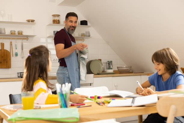 istock Man doing housework and helping his children with homework 1430616683