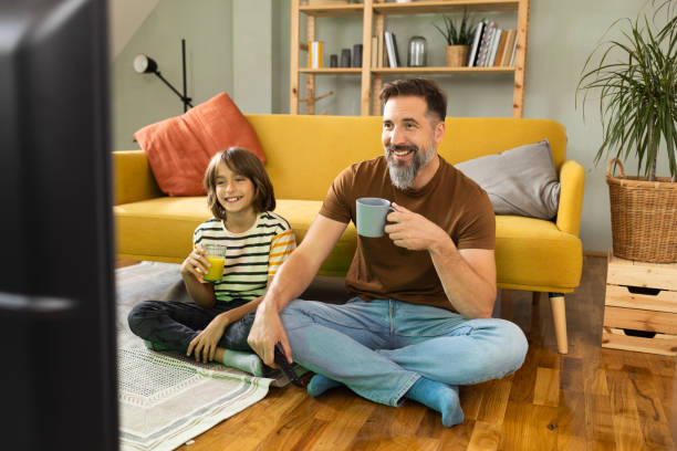 istock Happy man enjoying watching TV with his boy 1430616786