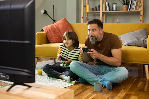 istock Gather and son playing video games and enjoying at home 1430616793
