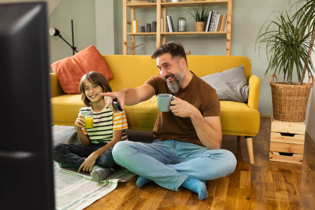 istock Father and son watching TV and having fun at home 1430616795