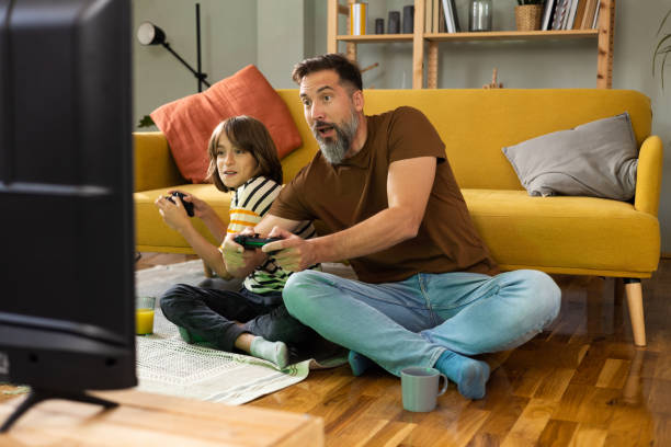 istock Boy and his dad having fun gaming at home 1430616802