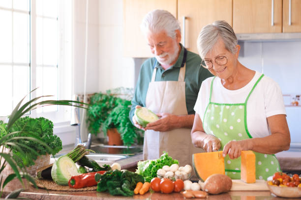 istock Attractive senior couple working together in home kitchen preparing vegetables. Elderly smiling couple enjoying healthy lifestyle 1430617759