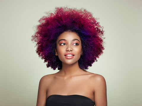 Beauty portrait of African American girl with colorful dyed afro hair. Beautiful black woman. Cosmetics, makeup and fashion