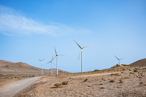wind turbines on the side of a mountain road