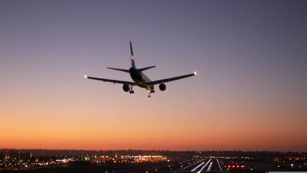 luces de la pista del aeropuerto por la noche, avión o aerolínea aterrizando a la pista de aterrizaje al atardecer. - sunset to night fotografías e imágenes de stock