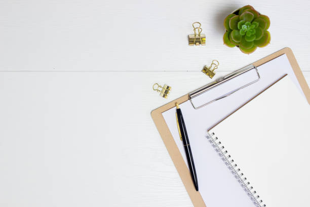 istock Working items with mobile phone, notebook, pen and cactus over the white wooden table. 1430622738