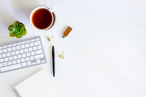 istock Working items with mobile phone, notebook, pen and cactus over the white wooden table. 1430622764