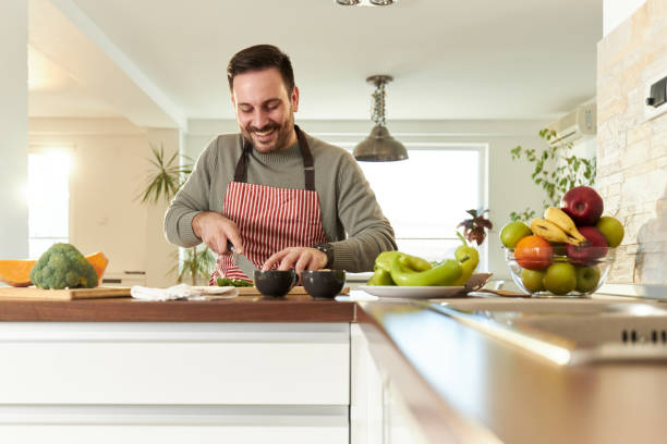 istock Happy bachelor cutting vegetables in the kitchen. 1430624802