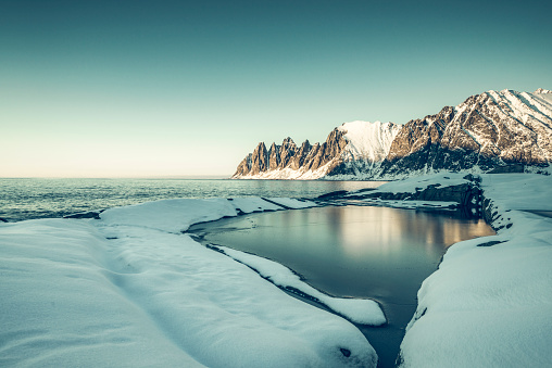 Sunset over the Okshornan mountain range at Tungeneset on the island of Senja in Northern Norway at the end of a beautiful day in winter.