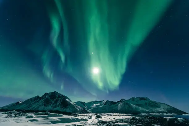 Photo of Northern lights or Aurora Borealis in night sky over Northern Norway during a cold winter night
