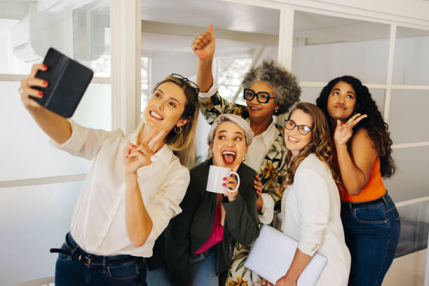 istock Cheerful businesspeople posing for a group selfie in an office 1430626045