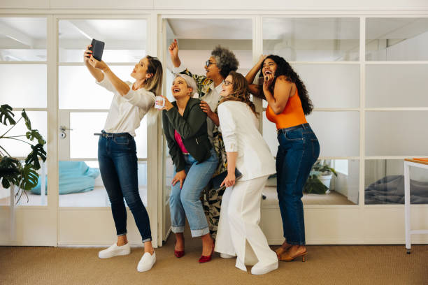 istock Happy businesspeople taking a group selfie in an office 1430626128