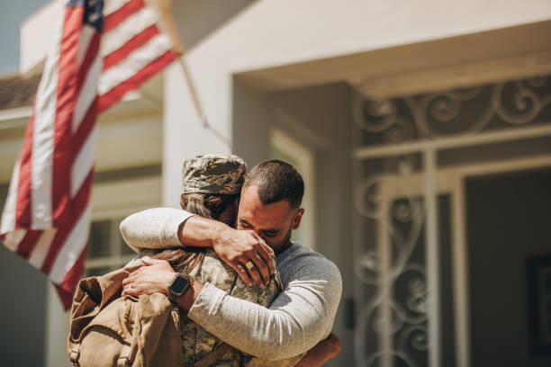 Emotional military homecoming Emotional military homecoming. Female soldier embracing her husband after returning home from the army. American servicewoman reuniting with her husband after serving her country in the military. military veteran stock pictures, royalty-free photos & images