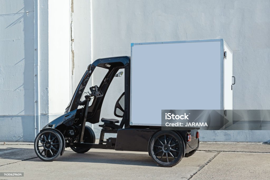 sustainable 4-wheel delivery cargo e-bike A modern electric delivery Quadracycle bike with a blank white cargo box with copy space for advertising. Electric Bicycle Stock Photo