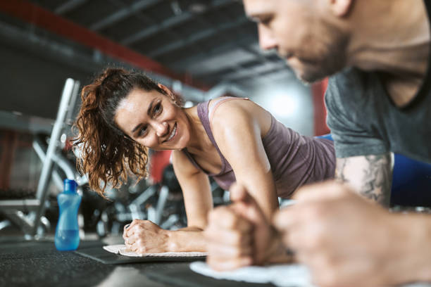 istock Happy athletic couple talking in plank position in a gym. 1430630714