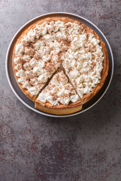 istock Sweet pie with a filling based on rice pudding topped with whipped cream and chocolate chips close-up in a plate. Vertical top view 1430638177