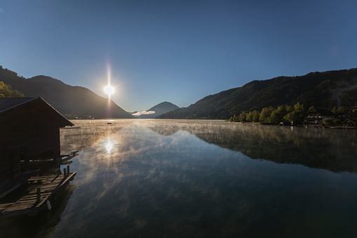 Tha sun begins to illuminate Lake Weissensee in the morning. The region is very famous in wintertime for ice skating and in summertime for hiking and mountainbiking.\nCanon EOS 5D Mark IV, 1/5000, f/2,8 , 16 mm.
