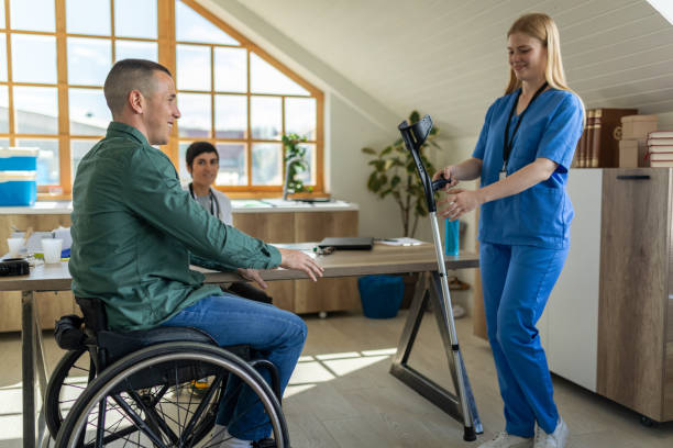 istock Nurse handing a disabled man crutches in a doctor's office 1430638631