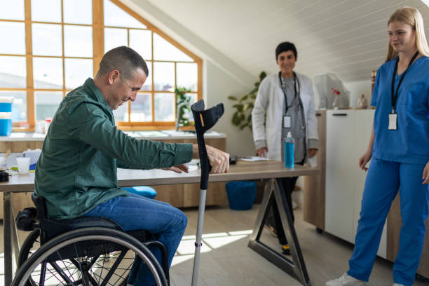 istock Nurse handing a disabled man crutches in a doctor's office 1430639568