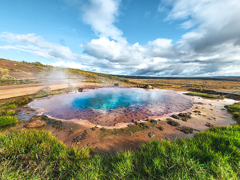 Colorful blue pool Blesi in Haukadalur geothermal field in Iceland. Inactive remains of a geyser.