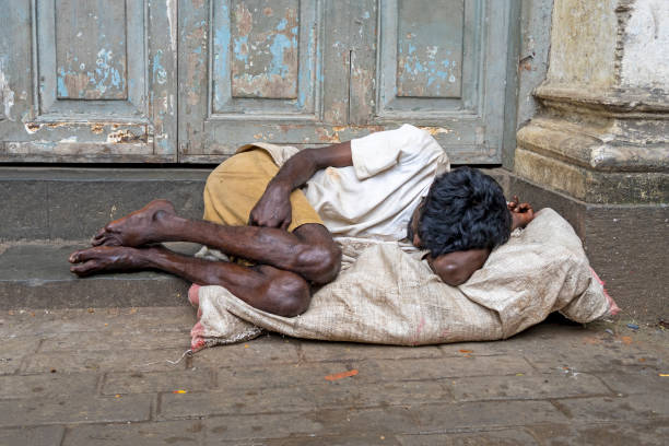 un sans-abri mendiant allongé sur le trottoir à mumbai en inde - street child photos et images de collection