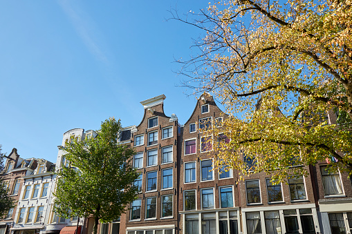 City street with narrow canal houses in Amsterdam, Netherlands