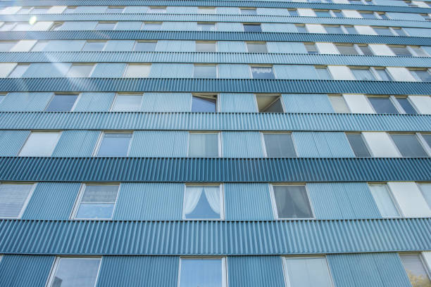 Looking up a blue and tall apartment building