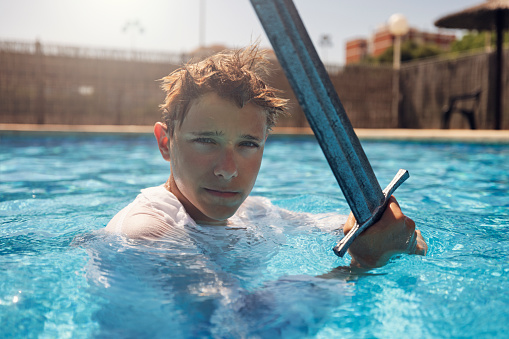 Teenage boy practicing sword fighting in swimming pool.
Shot with Canon R5