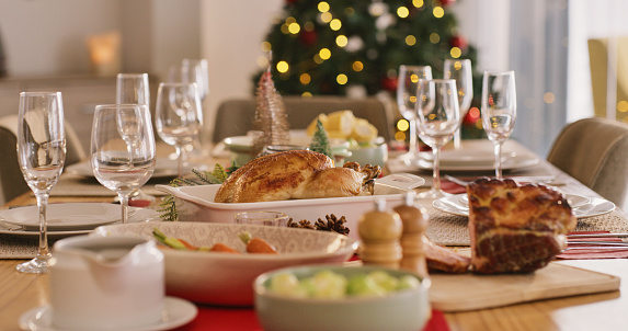 Table with Christmas dinner food catering for hungry family and fine dining room celebration in home. Christian religion holiday meal, serve salad hospitality and serve healthy plate with wine glass