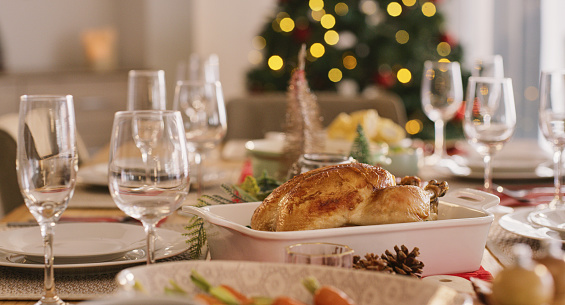 Food celebration, christmas tradition and feast with dining table decorated with glasses, healthy dishes and roast chicken or turkey. Lunch or dinner party for holiday or festive season at home