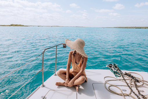 Joven relajándose en un viaje en catamarán en una hermosa laguna photo