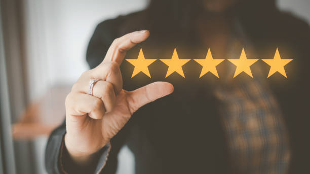 istock Customer Satisfaction Survey Concept, A woman's hand using a smartphone gives a 5 star rating to show the highest level of satisfaction with excellent service.. 1430660461