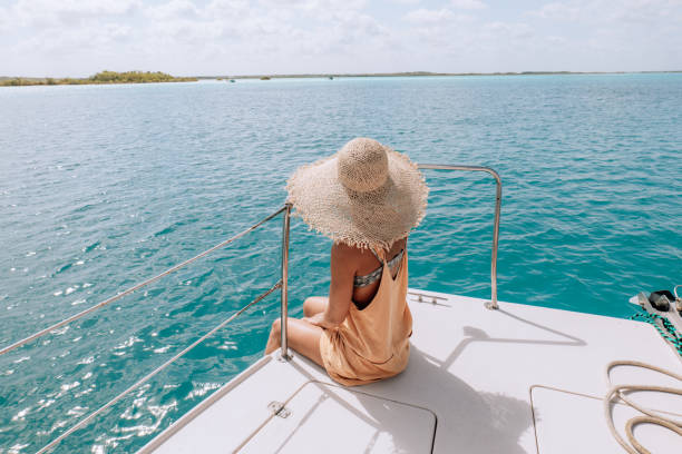 Young woman relaxing on a catamaran trip on a beautiful lagoon stock photo