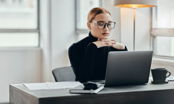 istock Thinking, planning and receptionist working on laptop in an office, planning and contemplating career change. Vision, goal and mission by young  employee bored at her desk job, focused on online task 1430663103