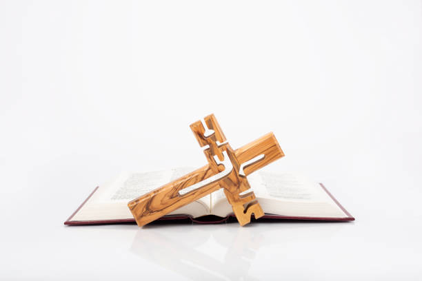 Bible with wooden cross isolated on white background