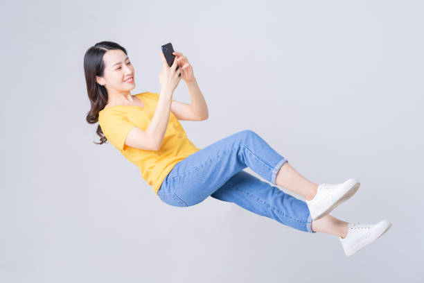 imagen de una mujer asiática cayendo - dropped call fotografías e imágenes de stock