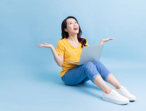 istock Image of young Asian woman sitting and using laptop 1430670047