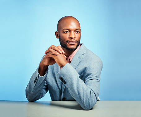 Black man, business fashion suit and thinking with motivation, vision and innovation idea on blue background in studio. Manager, worker and employee leadership with growth mindset for company success