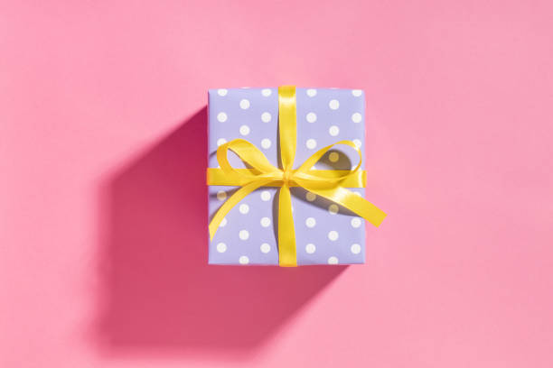 Violet Gift box with yellow ribbon on pink. This file is cleaned and retouched.