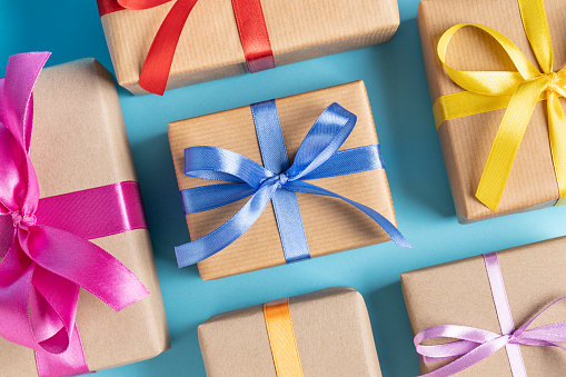 Close up of gift boxes with colorful ribbons on blue. This file is cleaned and retouched.