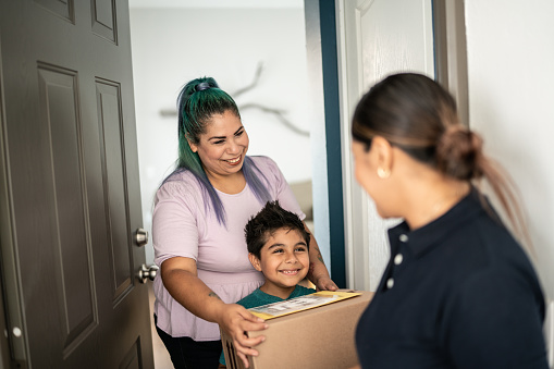 Mother and son receiving package at home entrance