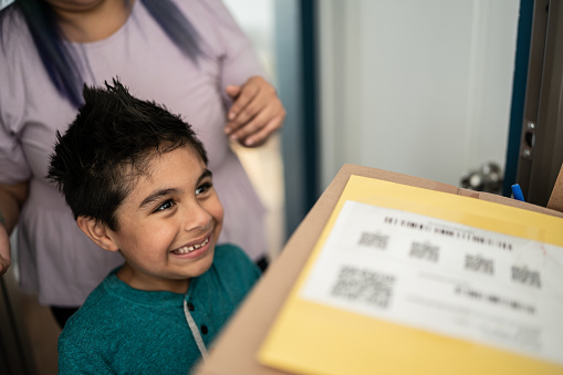 Mother and son receiving package at home entrance