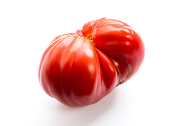 rosa erbstücktomate, auch heritage tomate genannt, auf weißem hintergrund. natürliche, hausgemachte, unvollkommene tomaten. große rote tomatenfrüchte. - tomato beefsteak tomato heirloom tomato pink stock-fotos und bilder
