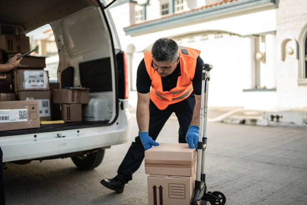istock Postal worker organizing van truck with cardboard boxes 1430676312