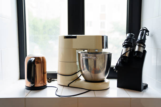 submersible mixer, blenders and electric kettle on the windowsill. storage and order in the kitchen. household appliances for professional chefs.