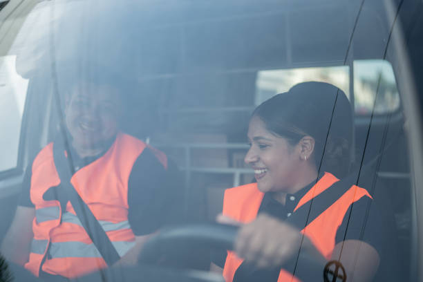 istock Postal workers driving a van truck to deliver packages 1430678471