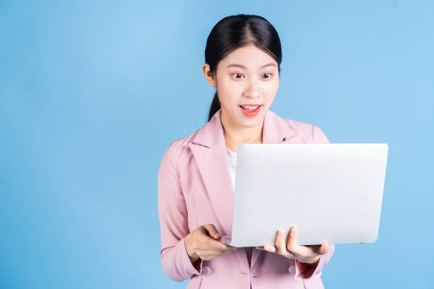 istock Young Asian business woman using laptop on background 1430678584