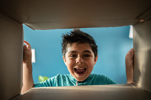 Little boy opening cardboard box